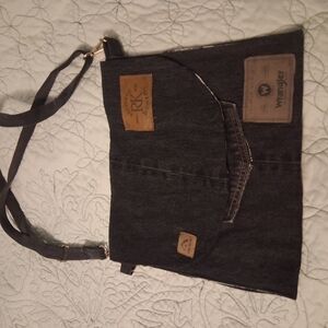 Handmaid blue jeans purse with pockets and an adjustable strap.
